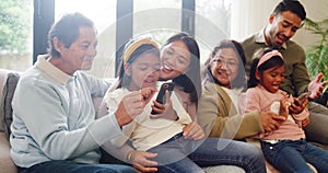 Family bonding together in the living room at home, playing mobile games or watching an online movie. Sibling sisters