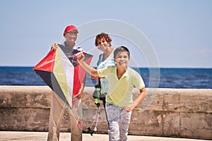 Family Boy And Grandparents Flying Kite Near Sea