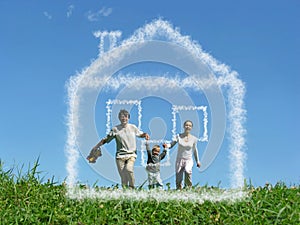 Family with boy on meadow and dream cloud house