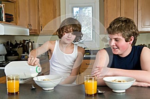 Family breakfast fun - teen brothers having cereal: candid shots