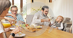 Family breakfast at home at table A man feeds his little son sitting in a