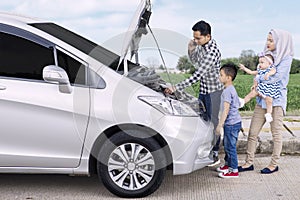 Family with broken car on roadside