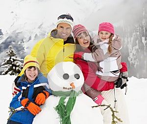 Family Building Snowman On Ski Holiday