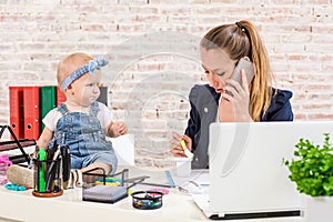 Family Business - telecommute Businesswoman and mother with kid is making a phone call