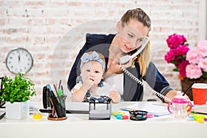 Family Business - telecommute Businesswoman and mother with kid is making a phone call