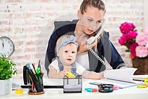 Family Business - telecommute Businesswoman and mother with kid is making a phone call