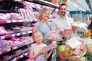 Family buying meat in supermarket.
