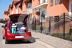 Family car with open trunk full of luggage in city