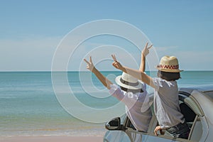 Family car trip at the sea, Woman and child cheerful raising their hands up and feeling happiness.