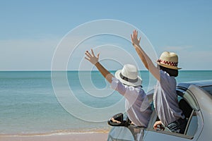 Family car trip at the sea, Woman and child cheerful raising their hands up and feeling happiness.