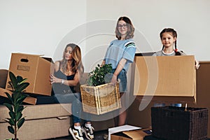 Family with cardboard boxes in new house at moving day