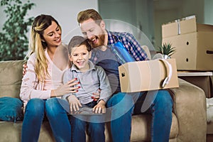 Family with cardboard boxes in new house at moving day