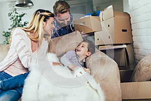 Family with cardboard boxes in new house at moving day