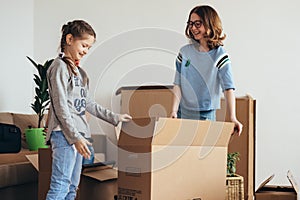 Family with cardboard boxes in new house at moving day