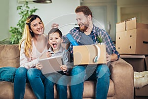 Family with cardboard boxes in new house at moving day