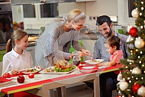Family celebrating Christmas - Mother serving turkey