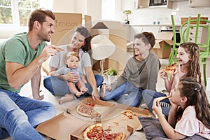 Family Celebrating Moving Into New Home With Pizza