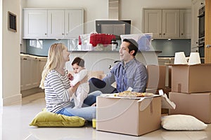 Family Celebrating Moving Into New Home With Pizza