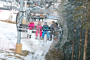 Family with chair lift going on ski terrain