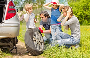 family changes the tyre of the car