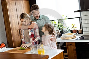 Family chatting and preparing food around a bustling kitchen counter filled with fresh ingredients and cooking utensils