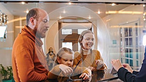 A family checking in the hotel - standing by the reception