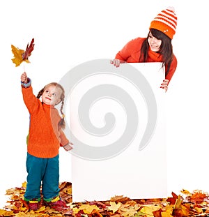 Family with child on autumn leaves holding banner.