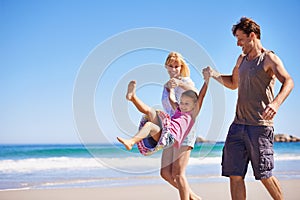 Family, child and bonding by swinging on beach, love and trust or having fun on summer holiday. Happy parents, daughter