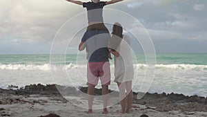 A family with a child looks at the ocean.