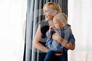 Family, child and parenthood concept. Happy smiling young mother with little baby at home