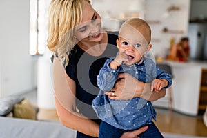 Family, child and parenthood concept. Happy smiling young mother with little baby at home