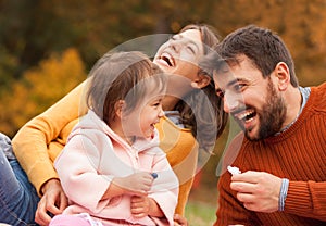 Family with child on picnic in autumn park.