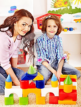 Family with child playing bricks.