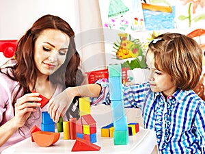 Family with child playing bricks.