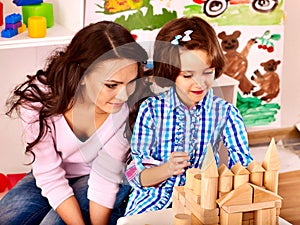 Family with child playing bricks.