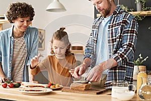 Family with child preparing sandwiches