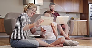Family, child and tablet for home games, e learning and funny interactive video on living room floor with parents