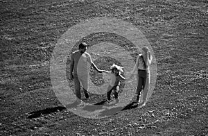 Family and child walking outdoors in summer nature.