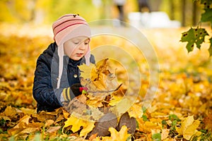 Family, childhood,fall season and people concept, happy girl playing with autumn leaves in park.little child, baby girl