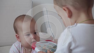 Family, childhood, infant concepts - Two children newborn baby and boy play with toys on bed. Siblings little boy and