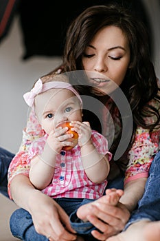 Family, childhood and parenthood concept - happy little baby learning to walk with mother help at home