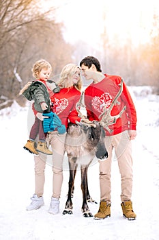 Family, childhood, season, holidays and people concept happy family in winter clothes over lights background