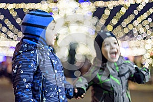 Family, childhood, season and people concept - happy in winter clothes over snowy city background