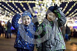 Family, childhood, season and people concept - happy in winter clothes over snowy city background