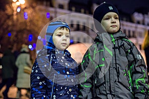 Family, childhood, season and people concept - happy in winter clothes over snowy city background