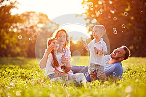 Family with children blow soap bubbles