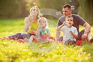 Family with children blow soap bubbles outdoor