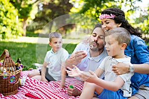 Family with children blow soap bubbles outdoors