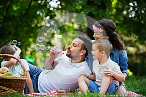 Family with children blow soap bubbles outdoors