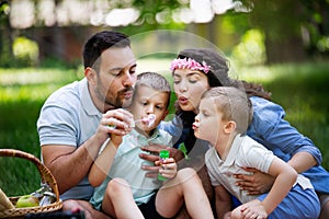 Family with children blow soap bubbles outdoors